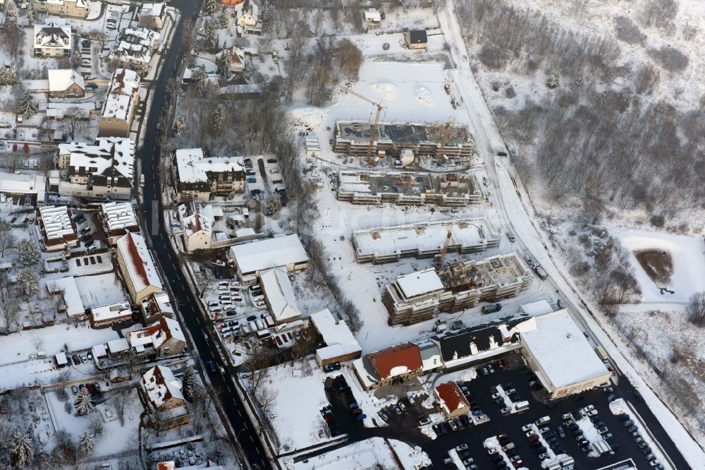 Berlin von oben - Winterlich schneebedeckte Baustelle zum Neubau einer Mehrfamilienhaus-Wohnanlage An der Schule im Stadtteil Mahlsdorf in Berlin