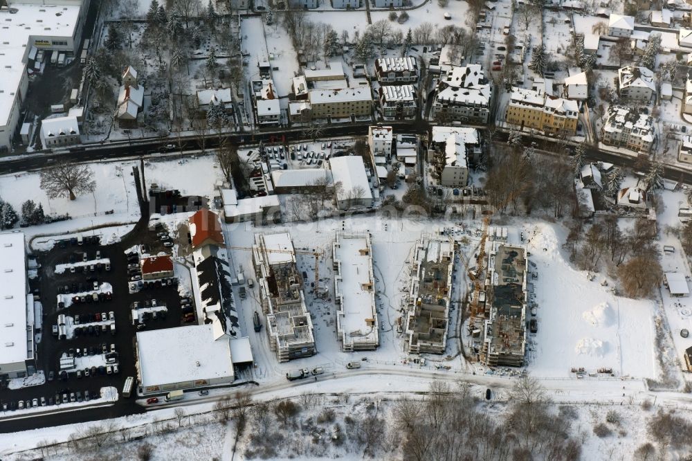 Luftaufnahme Berlin - Winterlich schneebedeckte Baustelle zum Neubau einer Mehrfamilienhaus-Wohnanlage An der Schule im Stadtteil Mahlsdorf in Berlin