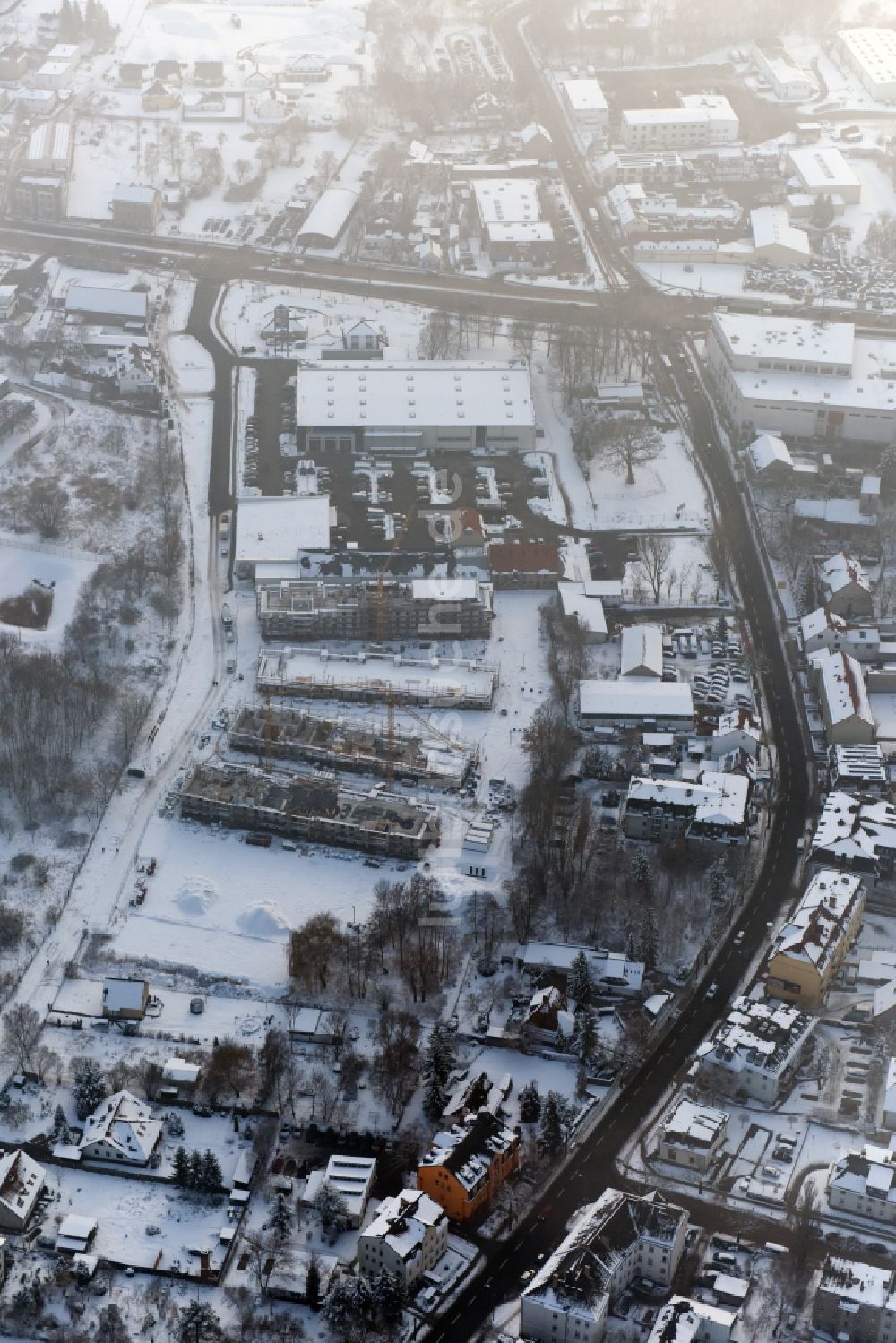 Berlin von oben - Winterlich schneebedeckte Baustelle zum Neubau einer Mehrfamilienhaus-Wohnanlage An der Schule im Stadtteil Mahlsdorf in Berlin