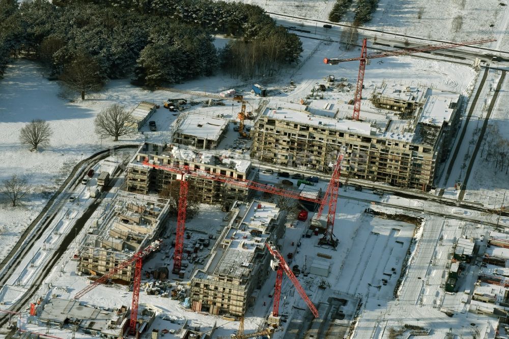 Berlin aus der Vogelperspektive: Winterlich schneebedeckte Baustelle zum Neubau der Mehrfamilienhaus-Wohnanlage „Wohnen am Campus“ an der Wilhelm-Hoff-Straße im Technologiepark Adlershof in Berlin