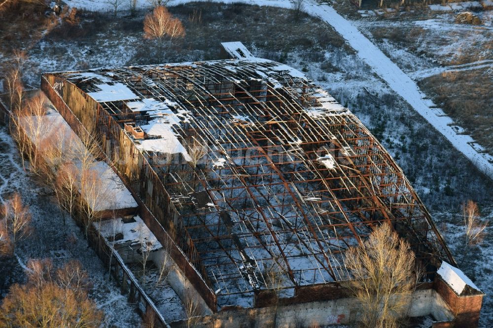 Luftaufnahme Oberkrämer - Winterlich schneebedeckte Dach- Löcher in der Ruine des ehemaligen Flugplatz- Hangars auf dem verlassenen Militärflughafen in Schönwalde im Bundesland Brandenburg