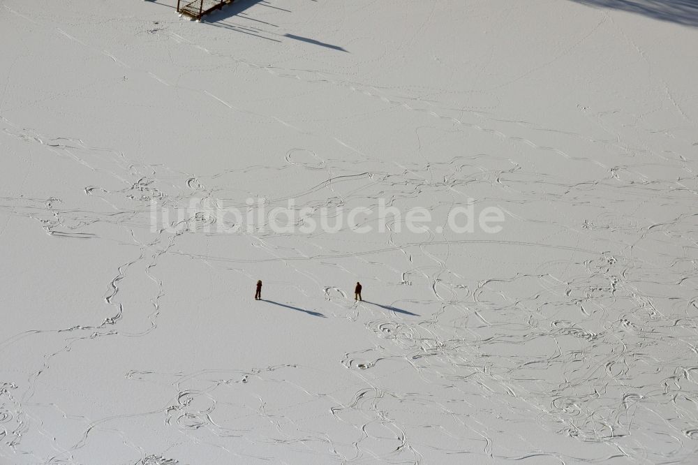 Beetzseeheide aus der Vogelperspektive: Winterlich schneebedeckte Eisfläche des Oberen Beetzsees in Päwesin mit zwei Schlittschuhläufern im Bundesland Brandenburg