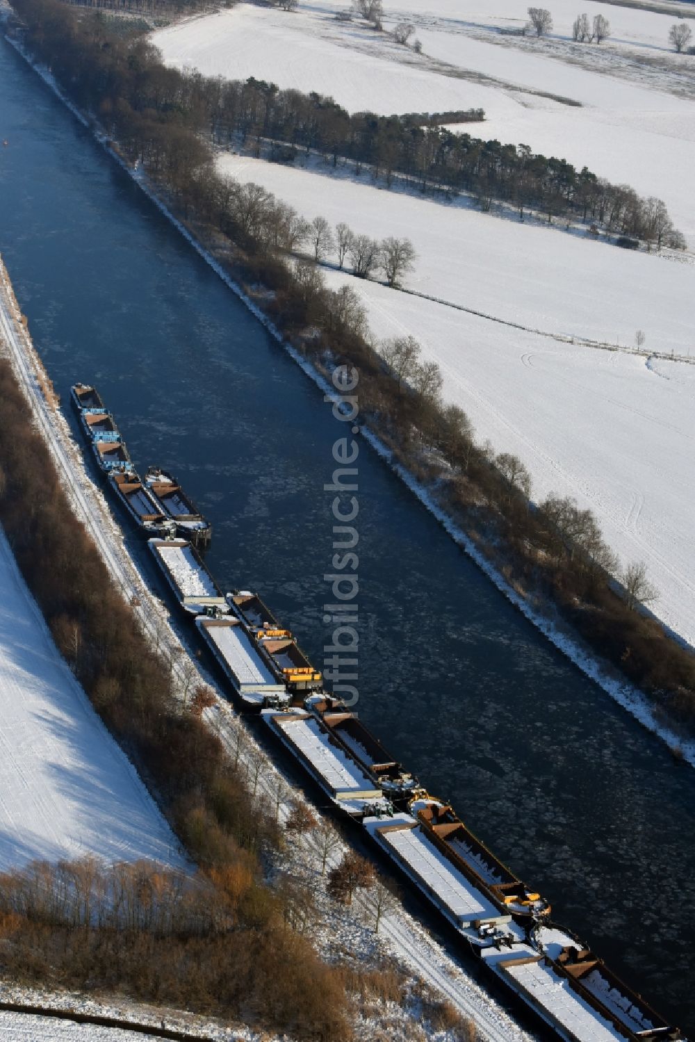 Burg von oben - Winterlich schneebedeckter Kanalverlauf mit festgemachten Lastkahn- Binnenschiff- Schubeinheiten am Ufer des Elbe-Havel-Kanal bei Burg im Bundesland Sachsen-Anhalt