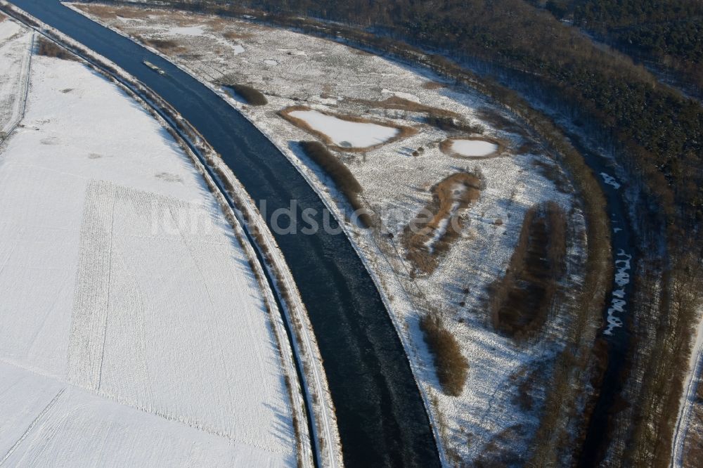 Burg von oben - Winterlich schneebedeckter Kanalverlauf und Uferbereiche am renaturierten Altarm des Elbe-Havel-Kanal bei Burg im Bundesland Sachsen-Anhalt