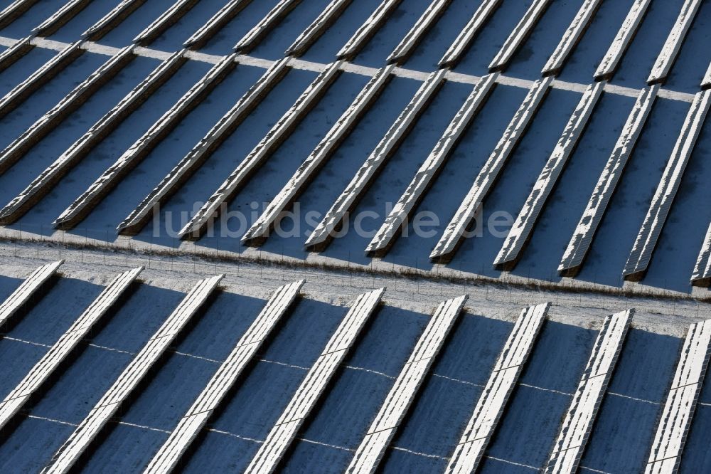 Werneuchen aus der Vogelperspektive: Winterlich schneebedeckter Solarpark bzw. Solarkraftwerk auf dem Flugplatzgelände in Werneuchen im Bundesland Brandenburg