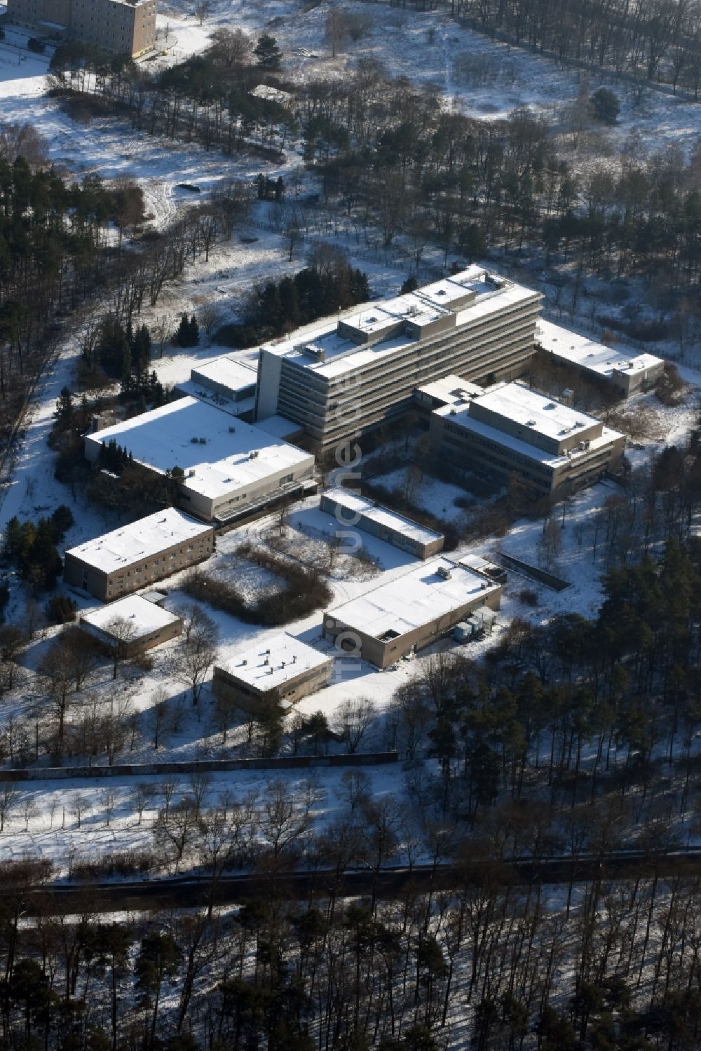 Luftaufnahme Berlin - Winterlich schneebedecktes Gebäude des ehemaligen Krankenhaus des MfS Ministerium für Staatssicherheit der DDR an der Hobrechtsfelder Chausseestraße / Wiltbergstraße in Berlin Buch