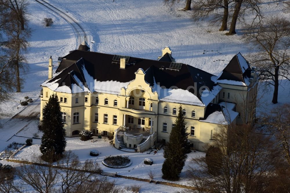 Krüssau von oben - Winterlich schneebedecktes Gebäude und Parkanlagen des Gutshauses und Herrenhauses Brandenstein in Krüssau im Bundesland Sachsen-Anhalt