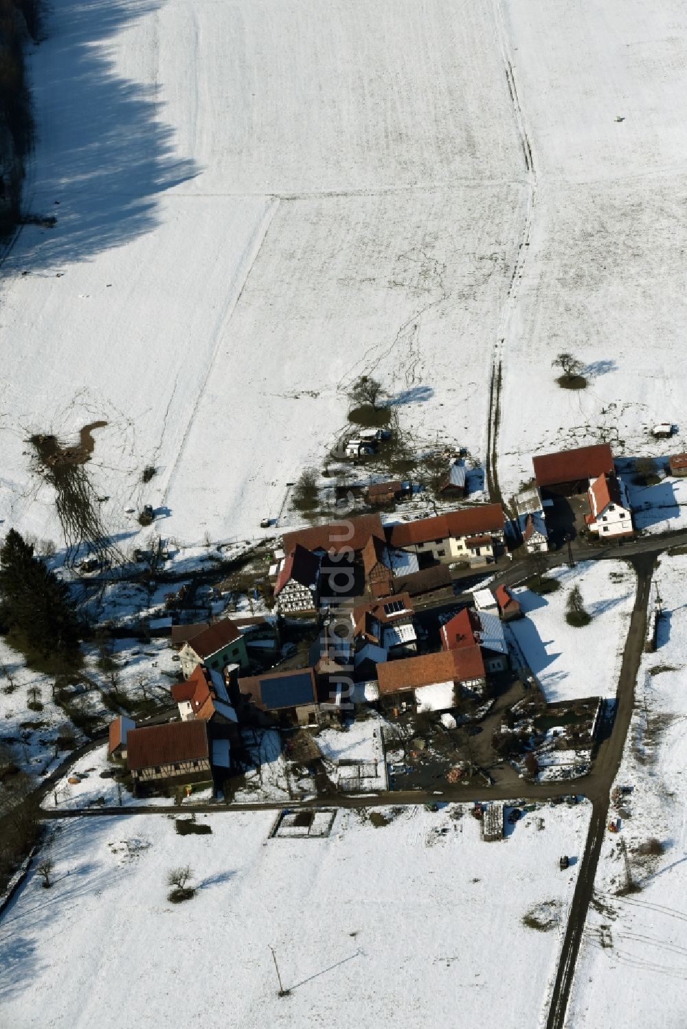 Weilar aus der Vogelperspektive: Winterlich schneebedecktes Gehöft eines Bauernhofes am Rand von bestellten Feldern in Weilar im Bundesland Thüringen