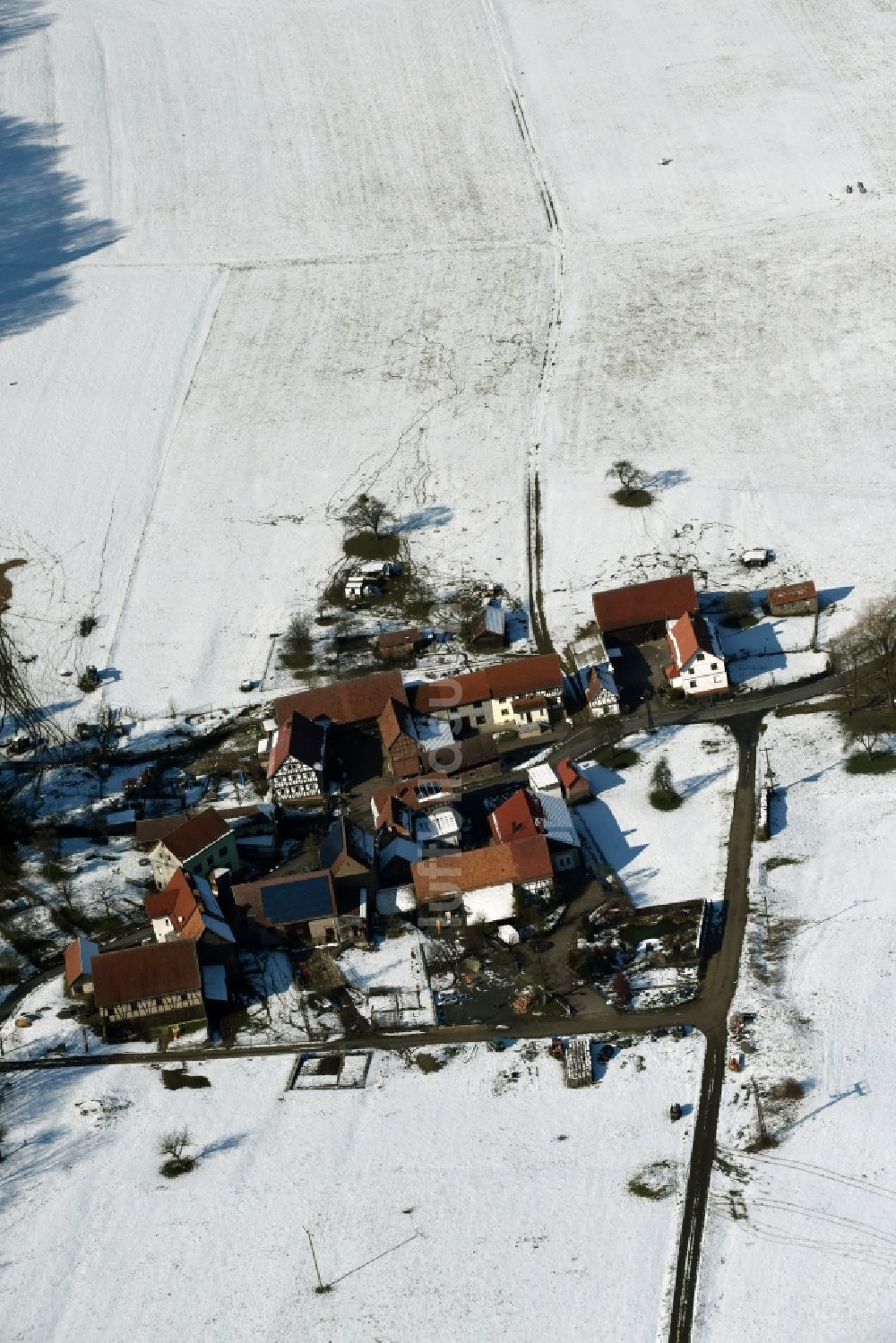 Luftbild Weilar - Winterlich schneebedecktes Gehöft eines Bauernhofes am Rand von bestellten Feldern in Weilar im Bundesland Thüringen