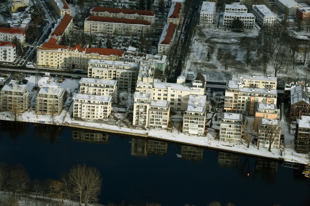 Luftaufnahme Berlin - Winterlich schneebedecktes Wohngebiet einer Mehrfamilienhaussiedlung am Ufer des Flußverlaufes der Spree in Berlin