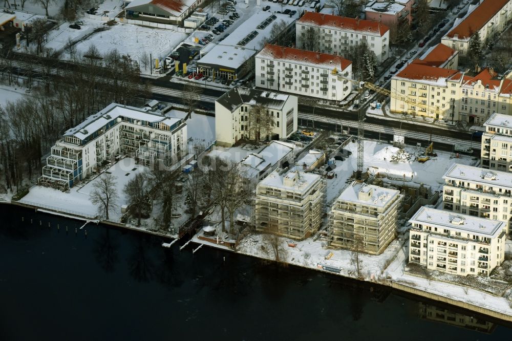 Berlin aus der Vogelperspektive: Winterlich schneebedecktes Wohngebiet einer Mehrfamilienhaussiedlung am Ufer des Flußverlaufes der Spree in Berlin