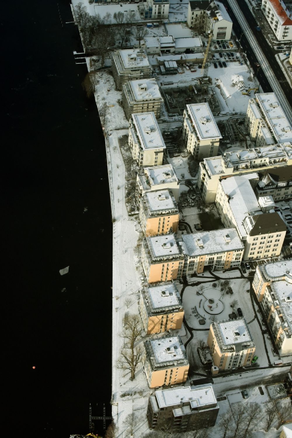 Luftaufnahme Berlin - Winterlich schneebedecktes Wohngebiet einer Mehrfamilienhaussiedlung am Ufer des Flußverlaufes der Spree in Berlin