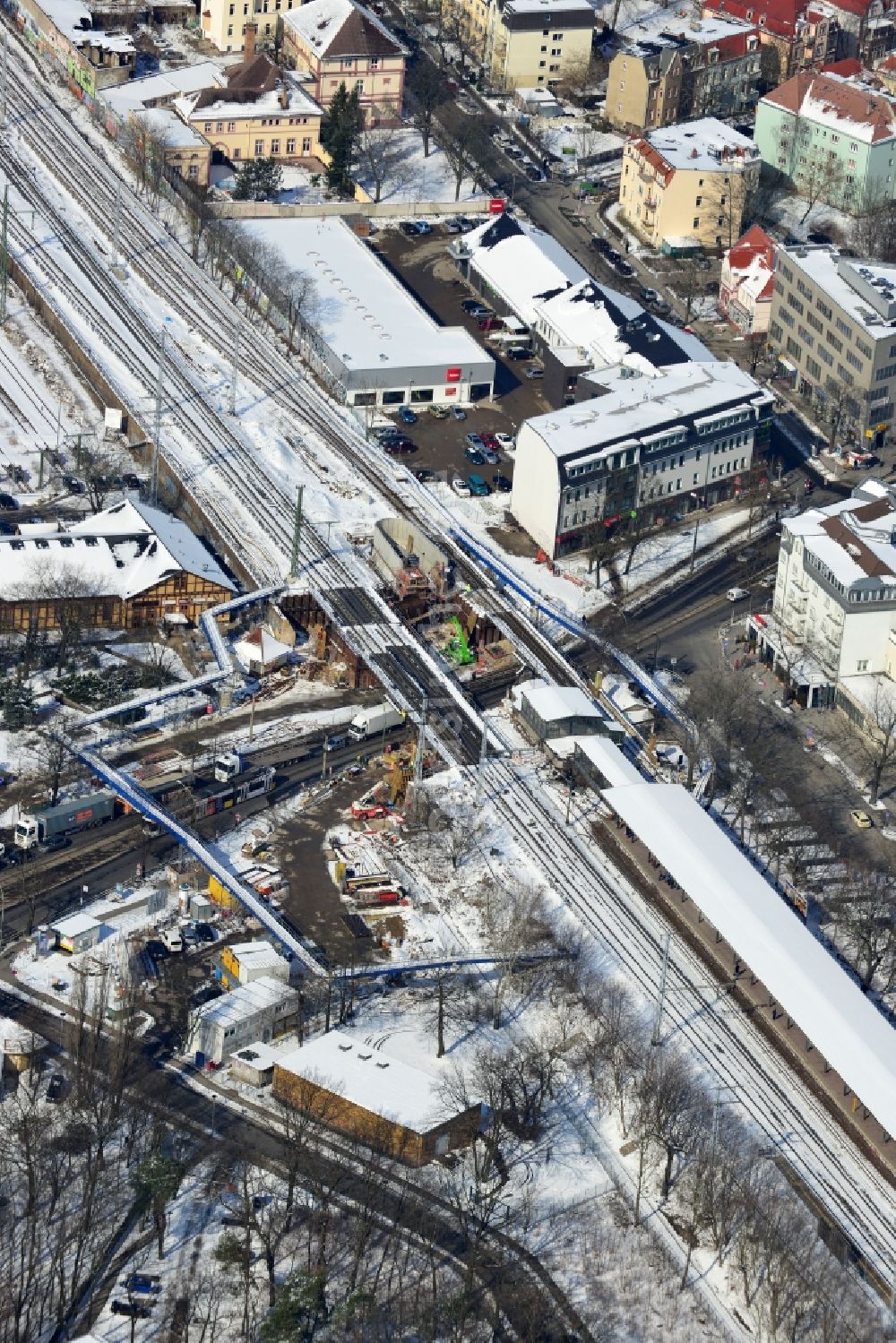 Luftaufnahme Berlin - Winterlich verschneite Baustelle zum Bau der neuen Eisenbahnbrücke über die Treskowallee am S- Bahnhof Berlin - Karlshorst