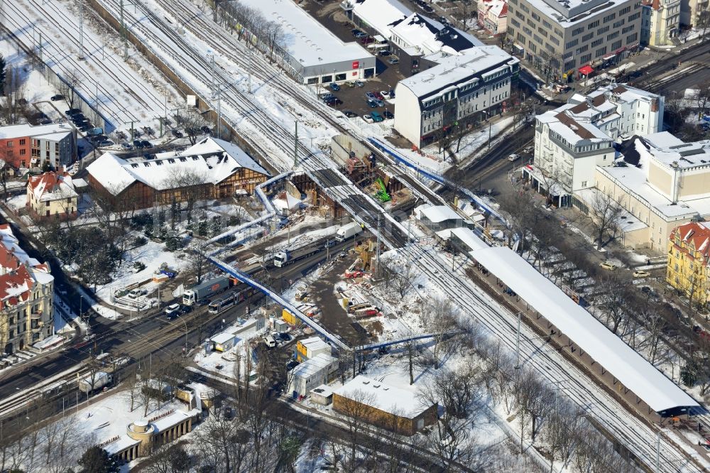 Luftaufnahme Berlin - Winterlich verschneite Baustelle zum Bau der neuen Eisenbahnbrücke über die Treskowallee am S- Bahnhof Berlin - Karlshorst