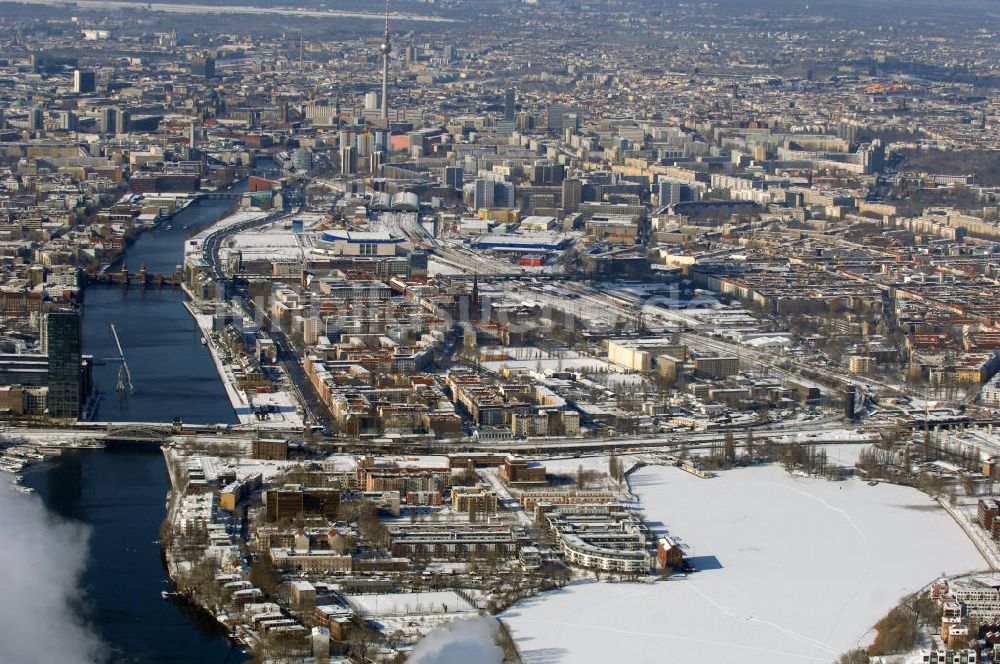 Berlin von oben - Winterlich, verschneite Stadtansicht Berlins vom Bereich des Berliner Osthafens mit der dahinter liegenden O2 Arena im Friedrichshain