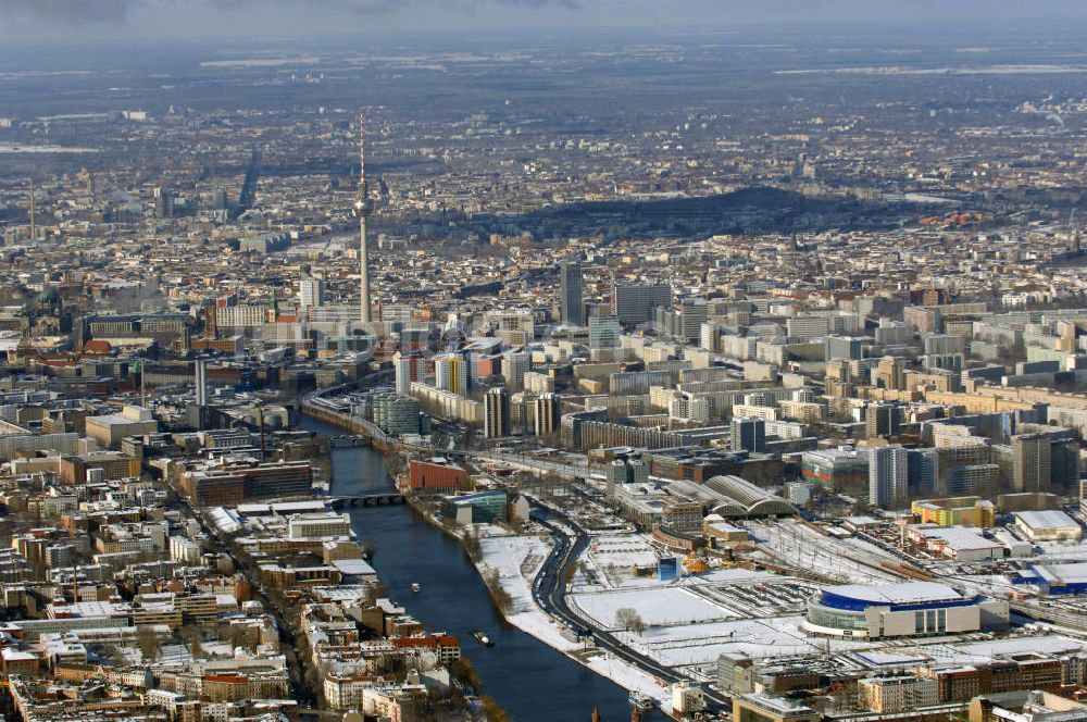 Luftbild Berlin - Winterlich, verschneite Stadtansicht Berlins vom Bereich des Berliner Osthafens mit der dahinter liegenden O2 Arena im Friedrichshain