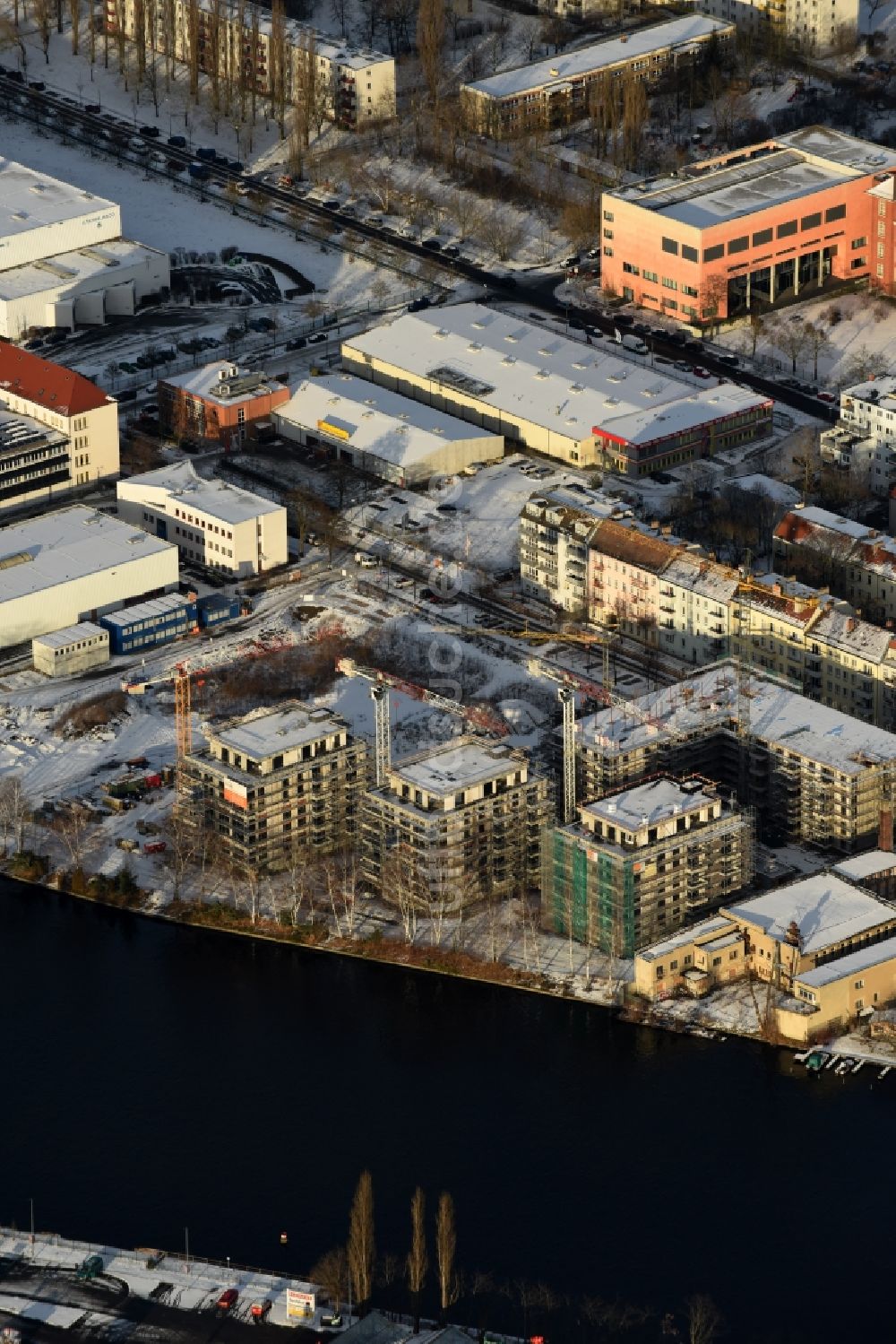 Luftaufnahme Berlin - Winterluftbild Baustelle zum Neubau einer Mehrfamilienhaus-Wohnanlage am Ufer des Flußverlaufes der Spree in Berlin