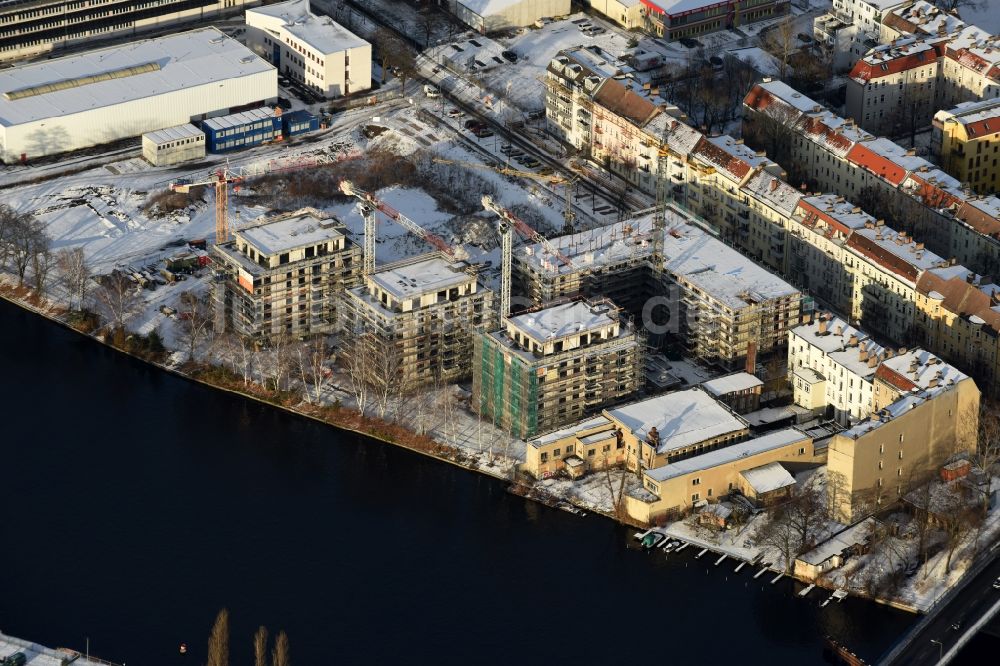 Berlin von oben - Winterluftbild Baustelle zum Neubau einer Mehrfamilienhaus-Wohnanlage am Ufer des Flußverlaufes der Spree in Berlin