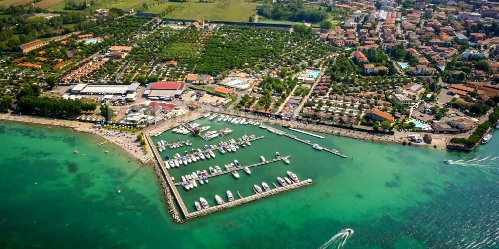 Peschiera del Garda aus der Vogelperspektive: Yachthafen mit Sportboot- Anlegestellen und Bootsliegeplätzen am Uferbereich in Peschiera del Garda in Veneto, Italien