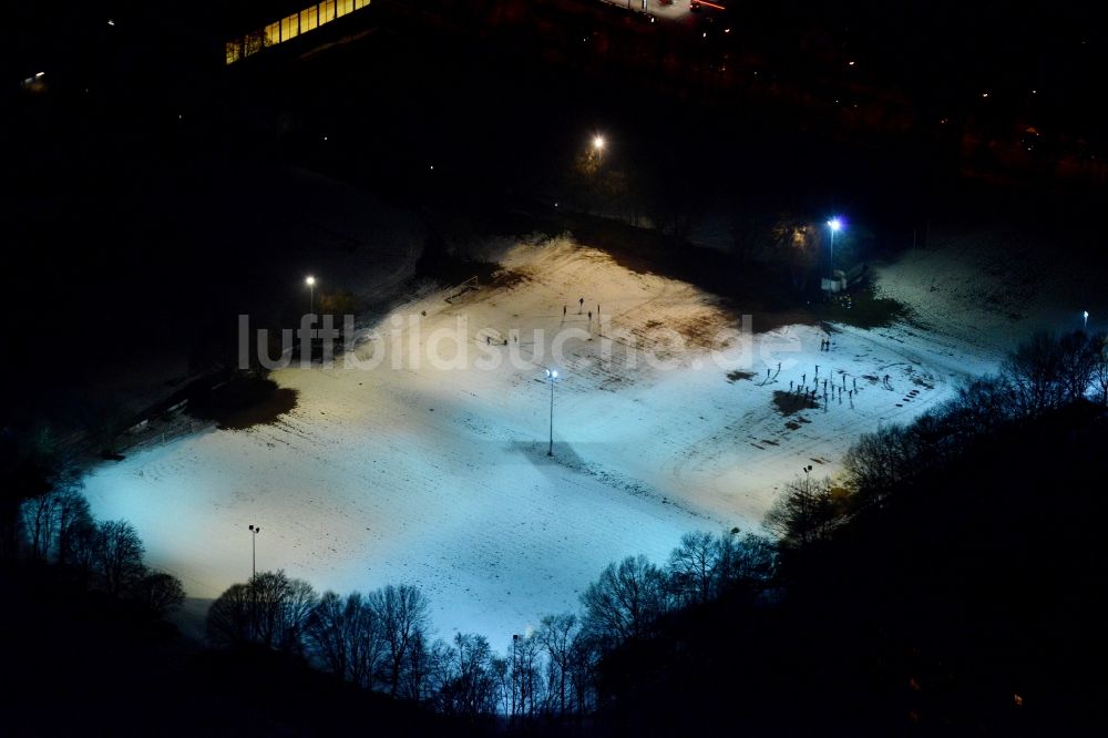 München bei Nacht aus der Vogelperspektive: Nachtluftbild der mit Schnee bedeckten Sportanlage Ramersdorf in München im Bundesland Bayern