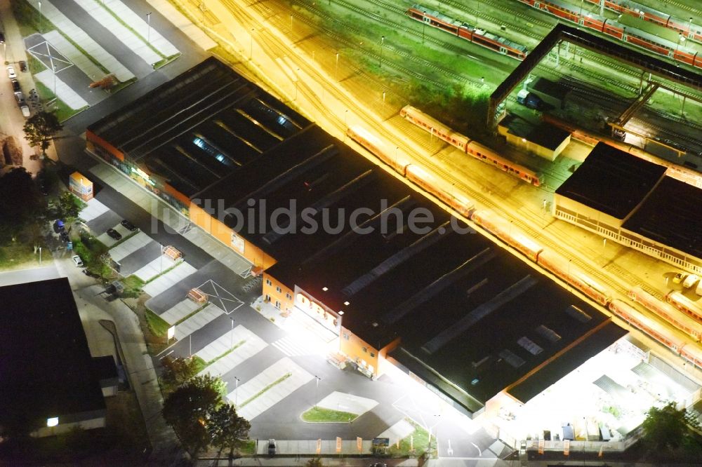 Berlin bei Nacht aus der Vogelperspektive: Nachtluftbild Gebäude des Baumarktes OBI Markt Berlin-Lichtenberg an der Buchberger Str in Berlin